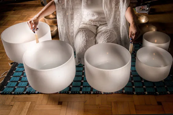 Woman playing sound healing bowls